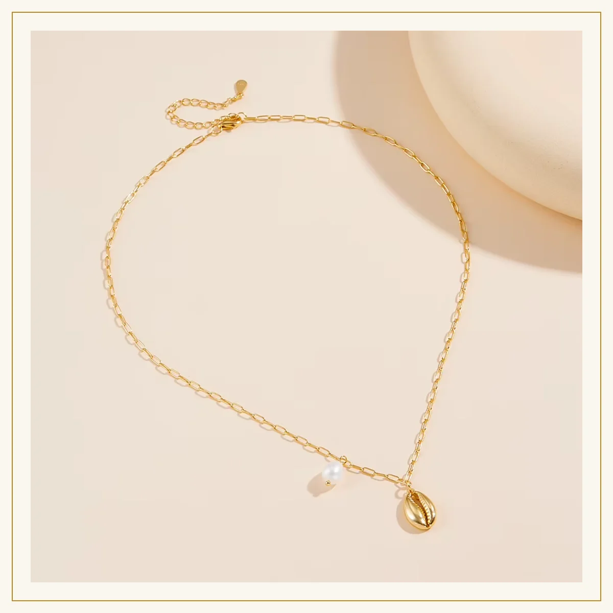 Cowrie shell and pearl paperclip chain necklace laid flat