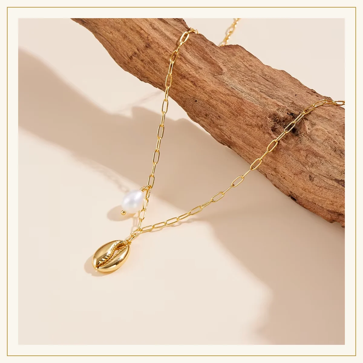 Close-up of gold cowrie shell pendant and pearl